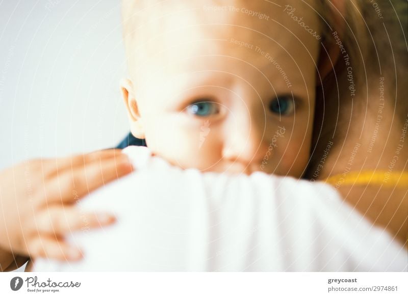 Ein unscharfes Porträt eines blauäugigen Babys, das seine Mutter umarmt, die es in den Armen hält Kind Mensch feminin Mädchen Junge Frau Jugendliche Erwachsene