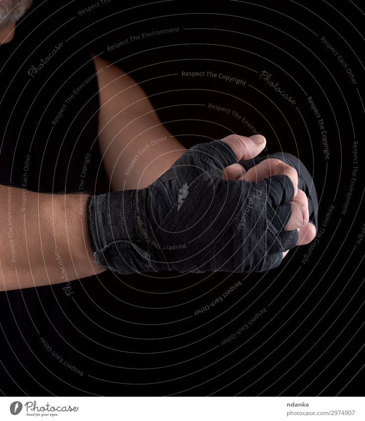 Hände eingewickelt in eine schwarze Sport-Textilbinde Lifestyle Körper Mensch Mann Erwachsene Arme Hand Fitness Aggression dunkel stark Kraft Macht Aktion