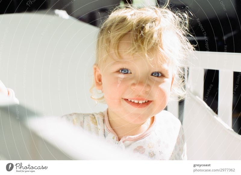 Porträt eines lächelnden Baby-Mädchens in ihrem Kinderbett Freude Bett Mensch feminin Kindheit 1 0-12 Monate blond Lächeln Fröhlichkeit kleines Mädchen Tochter