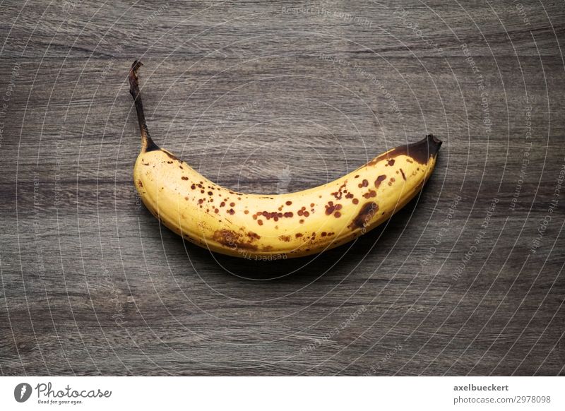 überreife Banana auf rustikalem Holzhintergrund Lebensmittel Frucht Ernährung Vegetarische Ernährung Gesunde Ernährung alt braun gelb Snack Banane Fleck