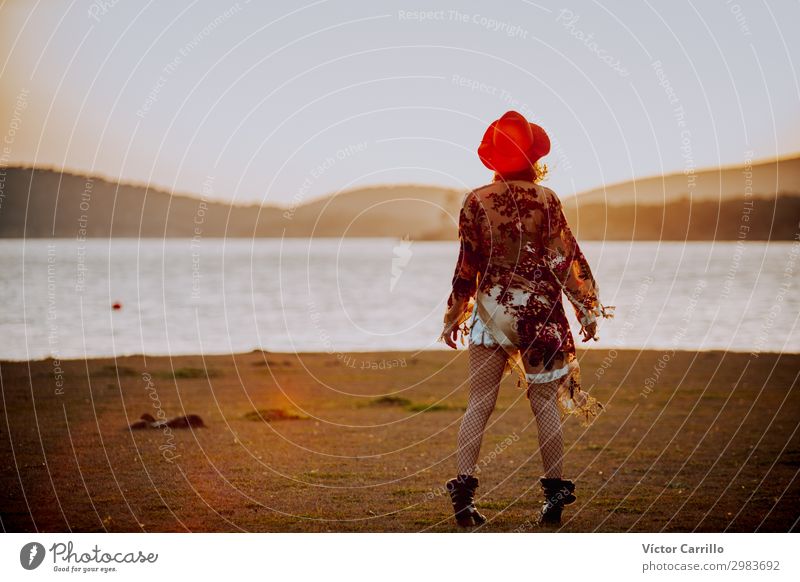 eine junge Frau mit rotem Hut in einem romantischen Sonnenuntergang in einem See. Lifestyle elegant Design exotisch Freude Mensch feminin Junge Frau Jugendliche