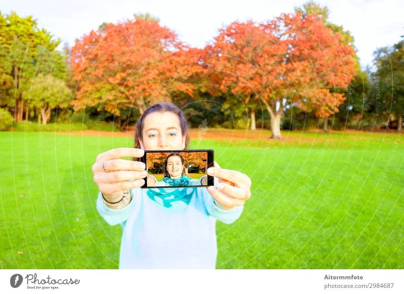 Frau, die Selfie nimmt Lifestyle Glück schön Ferien & Urlaub & Reisen Telefon PDA Fotokamera Internet Mensch Erwachsene Natur Herbst Park Mode Lächeln
