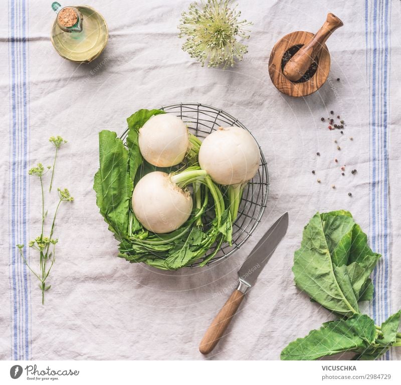 Rohe junge Rübe mit Grünzeug auf hellem Küchentisch mit Messer, Draufsicht. Konzept für gesundes vegetarisches Essen und Kochen roh Suppengrün Licht Tisch