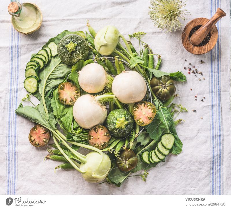 Verschiedene grüne Bio-Saisongemüse vom lokalen Bauernmarkt auf einem hellen Küchentisch, von oben gesehen. Konzept für gesundes vegetarisches Essen und Kochen. Saubere Lebensmittel