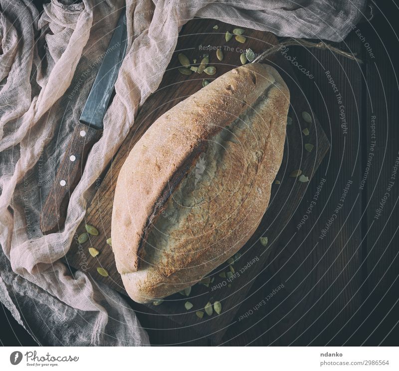 gebackenes knuspriges ovales Brot und Vintage-Messer Ernährung Essen Tisch Küche Holz frisch natürlich oben braun Tradition Bäckerei Holzplatte Kruste Mehl