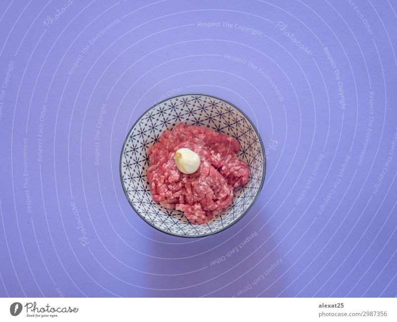 Hackfleisch in einer Schüssel auf violettem Hintergrund Fleisch Ernährung frisch rot Rindfleisch Burger Metzger Essen zubereiten Fett flache Verlegung