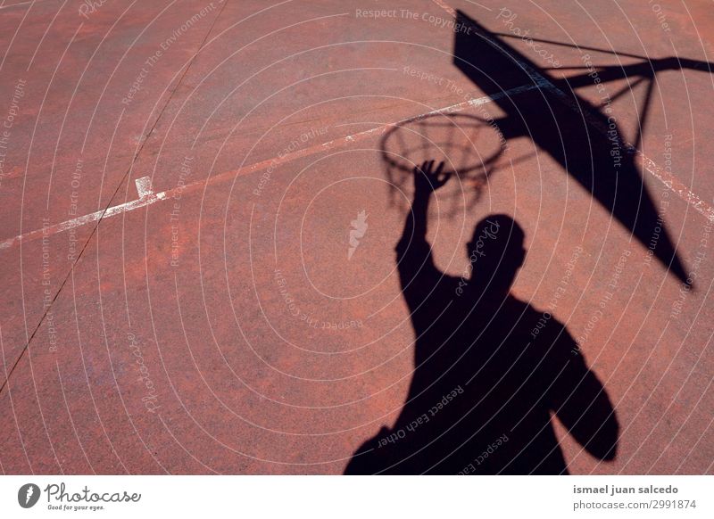 Mann spielt Basketball Schatten Silhouette auf der Straße Korb Sonnenlicht Boden Spielfeld Etage Sport Spielen aussetzen Park Spielplatz Außenaufnahme
