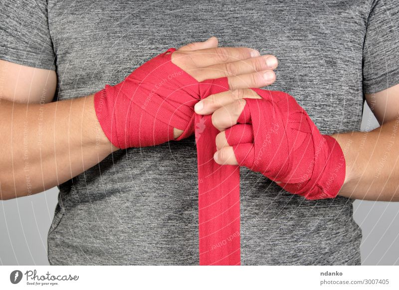 Sportlerhände eingewickelt in eine rote elastische Sportbinde Lifestyle Körper sportlich Fitness Mensch maskulin Mann Erwachsene Hand Bewegung stehen Aggression