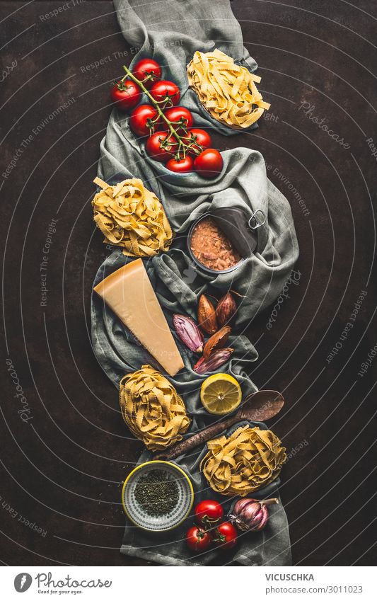 Thunfisch-Nudelkochzutaten auf dunklem, rustikalem Hintergrund, Ansicht von oben. Lebensmittelprodukte der italienischen Küche. Italienisches Essen. Kandierter Thunfisch. Vertikal. Flach liegend