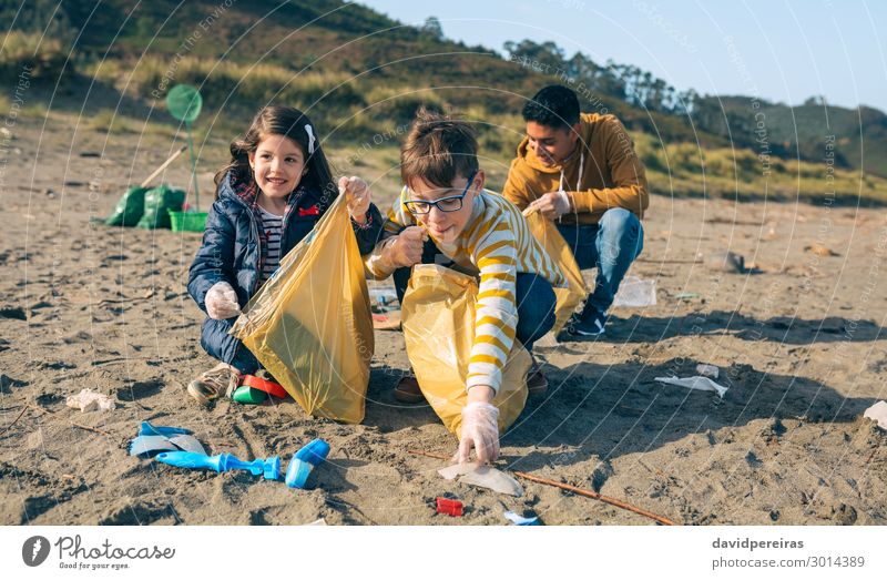 Junge Freiwillige reinigen den Strand Glück Camping Kind Arbeit & Erwerbstätigkeit Mensch Frau Erwachsene Mann Menschengruppe Sand Kunststoff Lächeln dreckig