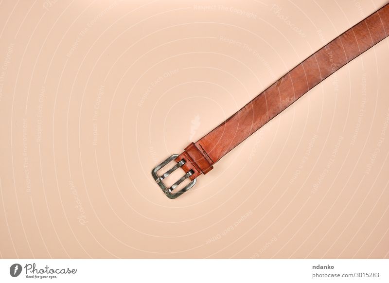 Fragment eines braunen Ledergürtels mit einer eisernen Schnalle elegant Stil Mode Bekleidung Stoff Accessoire Metall modern Aggression Gurt Hintergrund lässig
