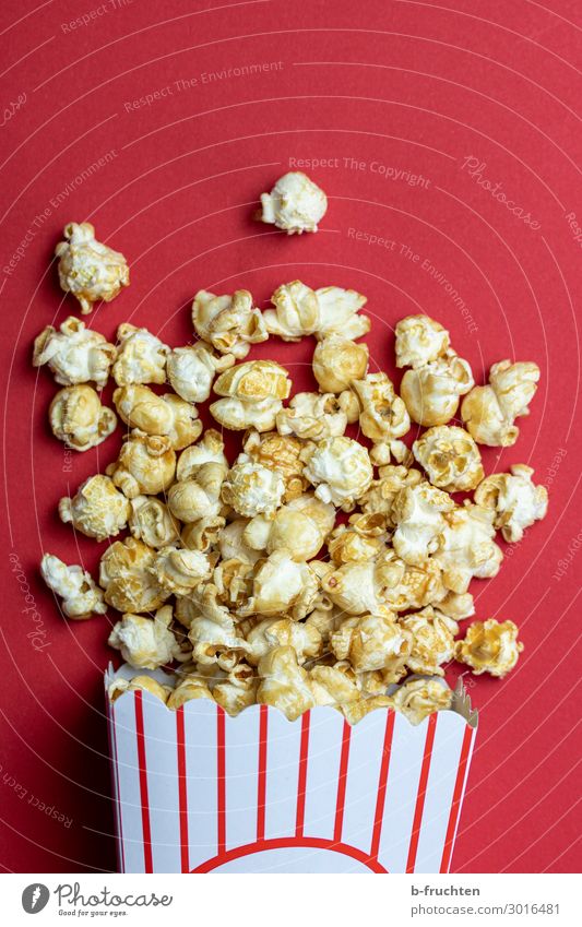 Eine Tüte Popcorn Lebensmittel Süßwaren Ernährung Fastfood Fingerfood Entertainment Papier Verpackung wählen genießen frisch rot Popkorn Kino liegen Snack Mais