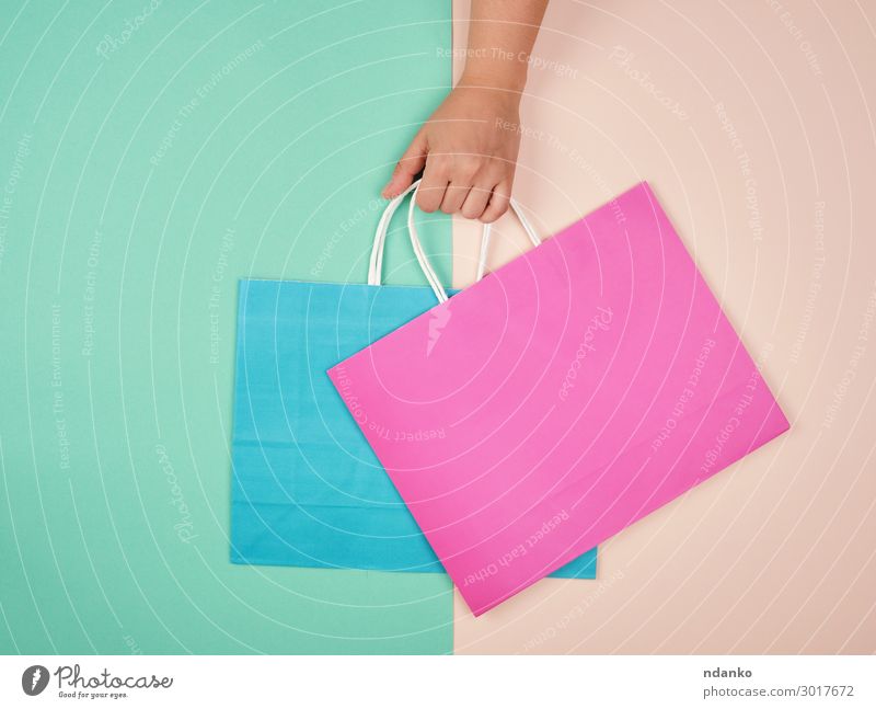 Hand hält zwei Papiertragetaschen Lifestyle kaufen Stil Design Business Frau Erwachsene Container Mode Verpackung Paket hängen modern neu grün rosa Farbe Idee