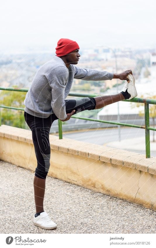 Schwarzer Mann beim Stretching vor dem Laufen im Freien. Lifestyle Körper Winter Sport Joggen Mensch maskulin Junger Mann Jugendliche Erwachsene Beine 1