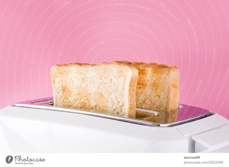 Geröstetes Toastbrot in weißem Toaster auf rosa Hintergrund. Brot bereit vereinzelt Lebensmittel Gesunde Ernährung Foodfotografie Frühstück Belegtes Brot