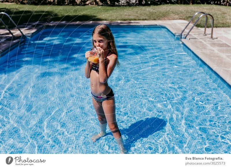 schönes Teenagermädchen am Pool, das Orangensaft trinkt. trinken Saft Lifestyle Freude Schwimmbad Spielen Ferien & Urlaub & Reisen Sommer Sonne Sport tauchen