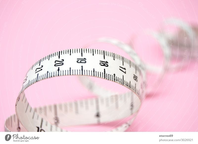 weißes Maßband isoliert auf rosa Hintergrund Zentimeter Meter Zähler Diät Beautyfotografie Entwurf Fitness Instrument Gewicht Nummer dünn Spirale Mode Lineal