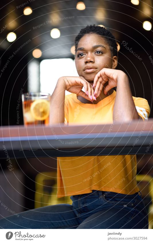 Schwarze Frau mit sehr kurzen Haaren nimmt ein Glas kalten Tee. Lifestyle Stil Glück schön Haare & Frisuren Gesicht Tisch Restaurant Mensch feminin Junge Frau