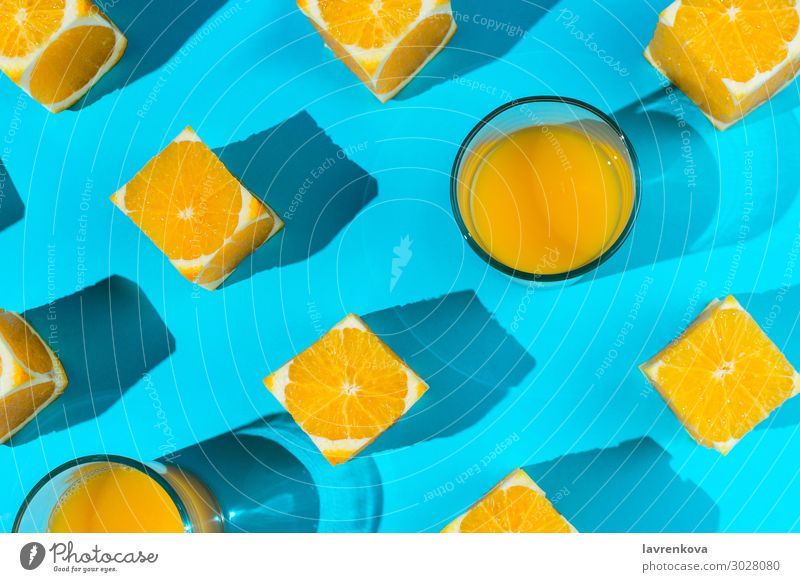 Orangen und Gläser mit Saft auf Blau Glas orange blau hell c Zitrusfrüchte Würfel geschnitten Diät flach Lebensmittel Gesunde Ernährung Foodfotografie Frucht