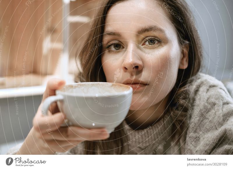 Junge erwachsene weiße Frau mit großer Tasse Latte Restaurant Pullover Jahreszeiten Getränk heiß Hygge Halt Tee Gesicht Becher Lifestyle Junge Frau Porträt