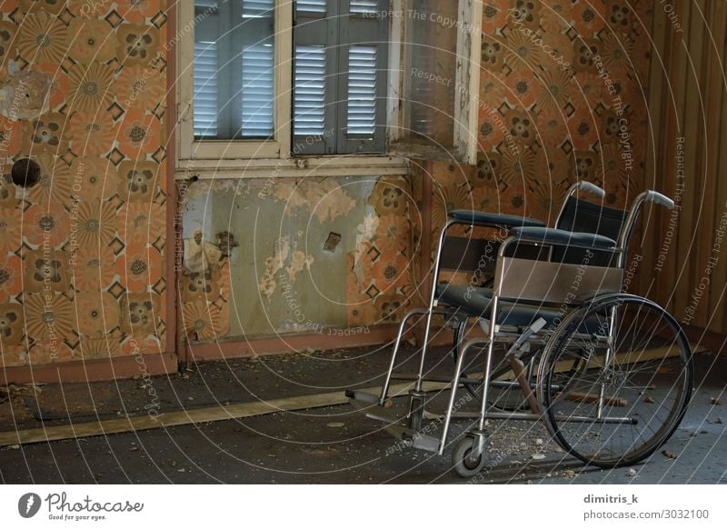 alter Rollstuhl und staubiger Boden im alten Haus Krankheit Stuhl Tapete Menschenleer Ruine gruselig retro Einsamkeit Verzweiflung vntage angeblättert Wand