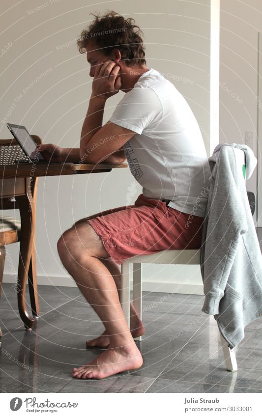 Mann sitz auf Stuhl und arbeitet am Laptop Notebook Tablet Computer T-Shirt Hose Jacke brünett kurzhaarig Locken Arbeit & Erwerbstätigkeit beobachten Denken
