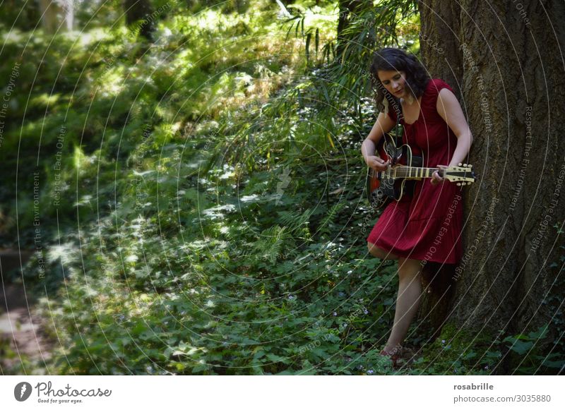 junge Frau im roten Kleid spielt Gitarre im Wald an einen Baum gelehnt | wen die Muse küsst Erholung Freizeit & Hobby Spielen Musik Junge Frau Jugendliche