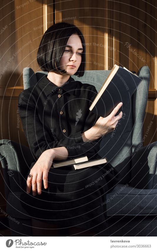 Frau sitzt auf einem Stuhl und liest Bücher. Buch gemütlich Kleid gesichtslos Finger Hand Freizeit & Hobby Halt heimwärts Hygge Lifestyle Porträt lesen ruhen