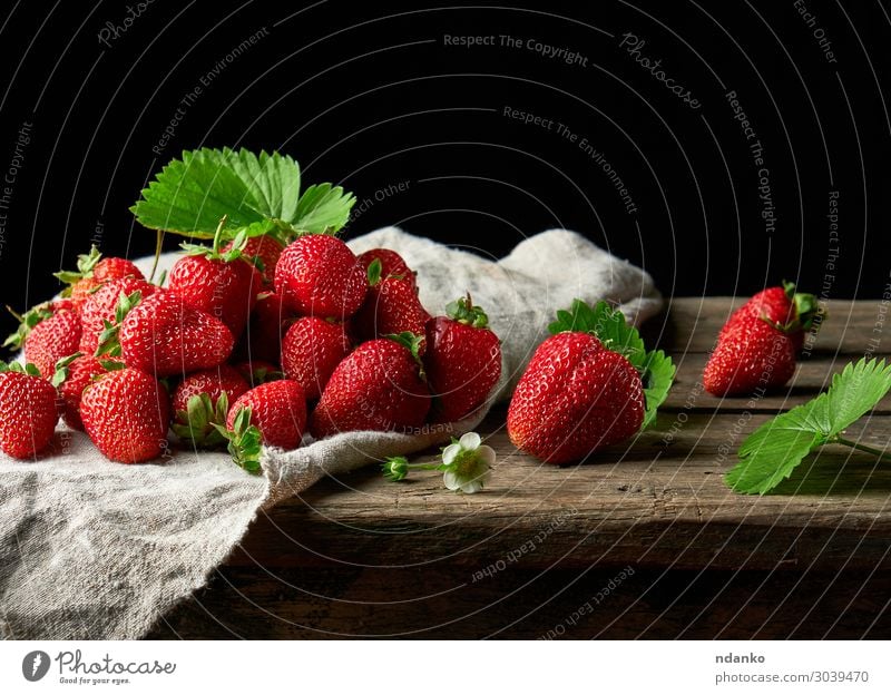 Bund frischer reifer roter Erdbeeren Frucht Dessert Vegetarische Ernährung Sommer Tisch Natur Blatt Holz Essen dunkel klein lecker natürlich saftig grün schwarz