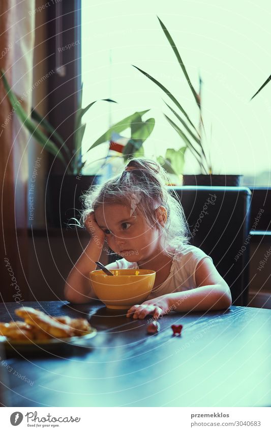 Kleines Mädchen beim Frühstücken Essen Lifestyle Tisch Kind Mensch Familie & Verwandtschaft 1 3-8 Jahre Kindheit Denken sitzen authentisch klein natürlich