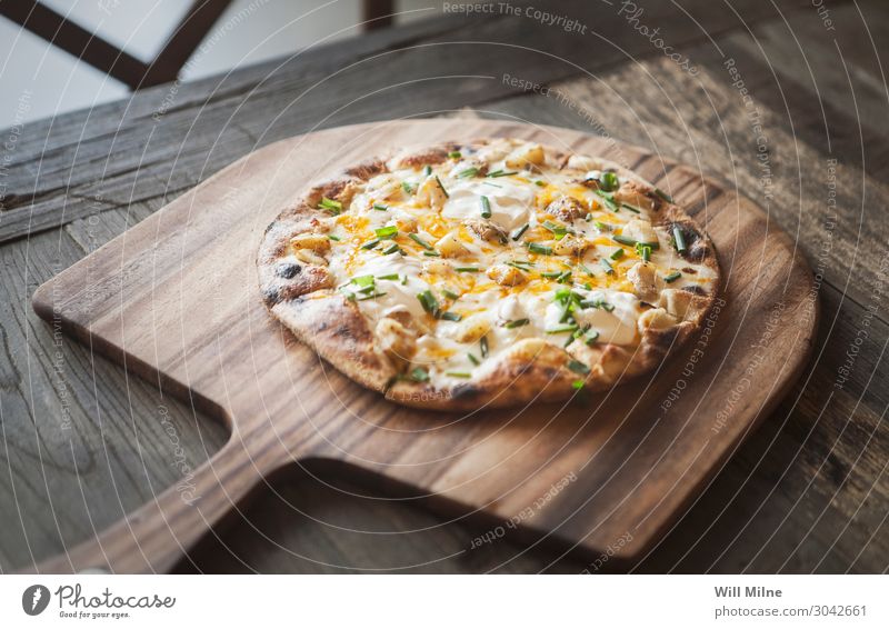 Eine frisch gebackene Pizza auf einem Holztablett. Lebensmittel Käse Teigwaren Backwaren Essen Mittagessen Fastfood Italienische Küche Restaurant Auflauf