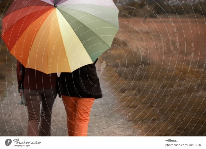 Harmonie beim Spaziergang mit einem großen bunten Regenschirm Menschen zwei Personen spazieren wandern Regenwetter Freizeit & Hobby Wochenende gehen 2