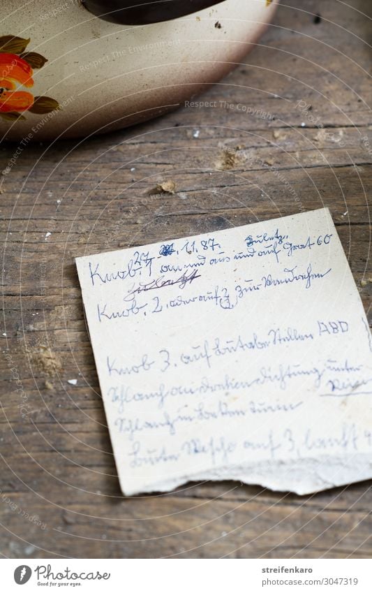 Handgeschriebener alter Zettel neben Kochtopf auf altem Küchentisch Lebensmittel Suppe Eintopf Knoblauch Ernährung Mittagessen Topf Wohnung Holz schreiben Armut