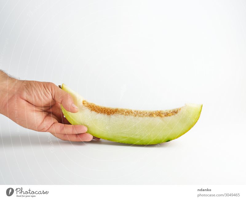 männliche Hand hält ein Stück reife Melone mit Samen. Gemüse Frucht Dessert Ernährung Vegetarische Ernährung Diät Sommer Natur Pflanze Essen frisch natürlich