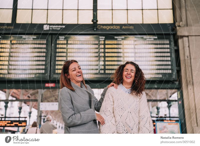 Zwei schöne Frauen, die am Bahnhof zusammen lachen. Lifestyle Glück Ferien & Urlaub & Reisen Tourismus Ausflug Ferne Erwachsene Freundschaft Verkehr