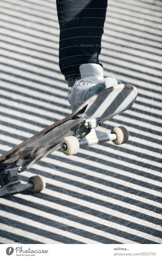 Fuß auf einem Skateboard, mit diagonalen Schatten, ganz schön schräg skaten Wheel Rollen Turnschuh Streifen Skateboarding Freizeit & Hobby Coolness