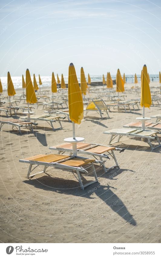 Verwaiste Sonnenliegen am Strand Urlaub Meer Mittelmeer Tourismus Massentourismus Leere menschenleer Liege Strandliege Sonnenschirm Sonnig Warm Abend Sand