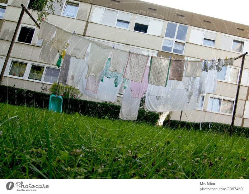 Sauber is anders Häusliches Leben Haus Garten Wiese Stadt Hochhaus Fenster Sauberkeit weiß Wäsche Wäscheleine Wäsche waschen Wäschekorb Hinterhof Unterhemd