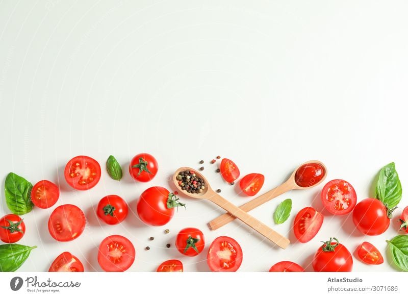 Flachliegende Komposition mit frischen Tomaten, Paprika, Basilikum und Holzlöffeln auf weißem Hintergrund, Platz für Text. Reifes Gemüse Gewürz legen