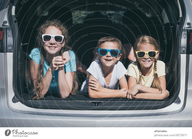 Der glückliche Bruder und seine beiden Schwestern sitzen zur Tageszeit im Auto. Kinder haben Spaß im Freien. Das Konzept der Familie ist reisefertig. Lifestyle