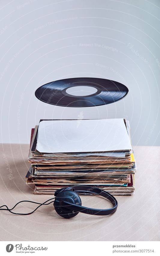 Schwarzes Vinyl hing in der Luft über einem Stapel von Vinyls. Lifestyle Stil Entertainment Musik Technik & Technologie Kultur Jugendkultur Subkultur
