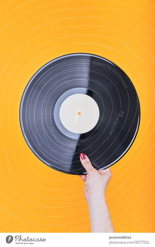 Vinylplatte über einem einfachen orangefarbenen Hintergrund Lifestyle Stil Spielen Entertainment Musik Technik & Technologie Musik hören Schallplatte Medien