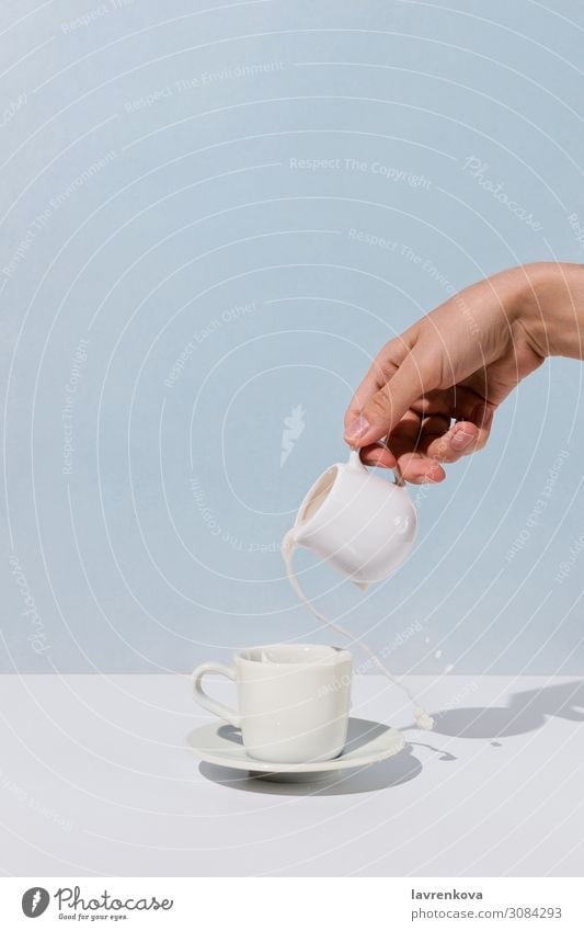 Frauenhand, die Mandelmilch in eine Tasse Kaffee gießt. aromatisch Getränk Frühstück Koffein Milchkännchen Hand heiß Lifestyle Morgen Becher eingießen