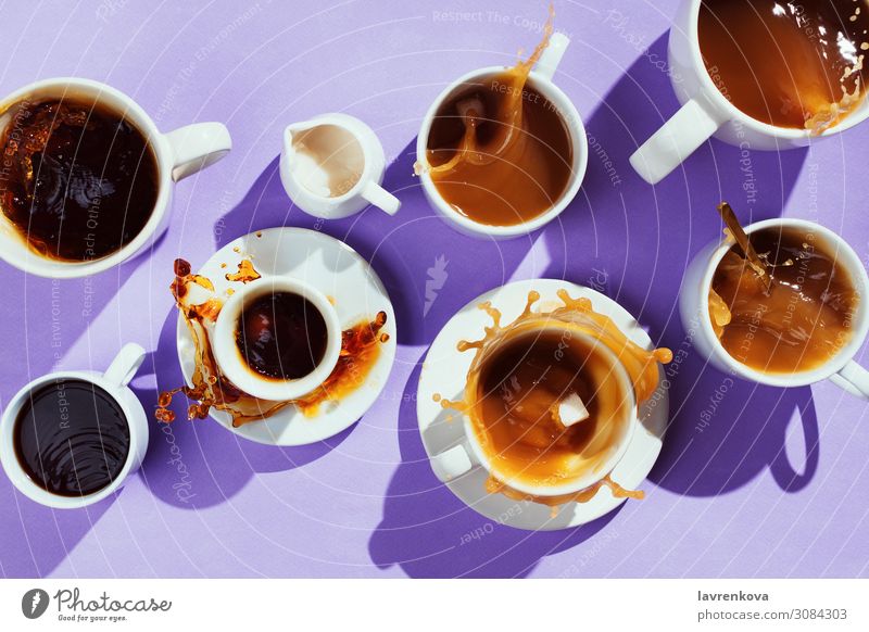 verschiedene Tassen mit Kaffee und Milchkännchen auf lila Becher Geschirr süß Löffel Cappuccino Zucker Latte Flachlegung Espresso schwarz heiß Geplätscher