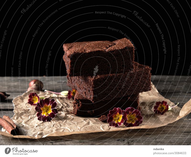 Stapel von gebackenen quadratischen Stücken von Schokoladenbrownie-Kuchen. Dessert Kakao Tisch Küche Papier Holz dunkel frisch lecker braun schwarz Bäckerei