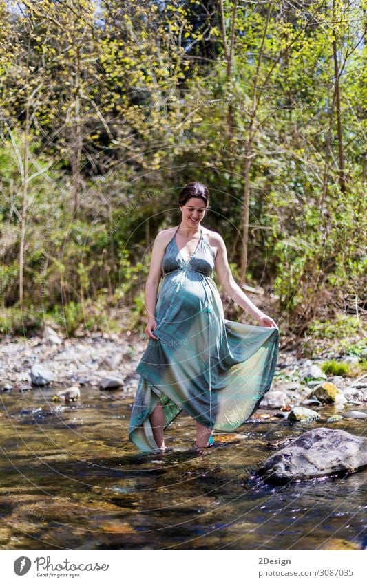 Schwangere Mädchen, die in der Nähe des Flusses posieren und ein grünes Kleid tragen. Lifestyle Stil Freude Glück schön Leben Erholung Freiheit Sommer Meer