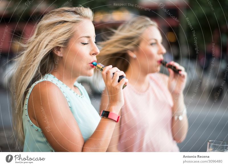zwei blonde Schwestern mit E-Zigarren-Rauchen auf der Bar-Terrasse Lifestyle elegant schön Freizeit & Hobby Technik & Technologie Mensch Frau Erwachsene Hand