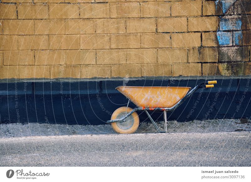 alte gelbe Schubkarre auf der Straße Rad Metall Bauarbeiter Gerät Werkzeug Arbeit & Erwerbstätigkeit Verkehr Außenaufnahme bauen Objektfotografie Stillleben