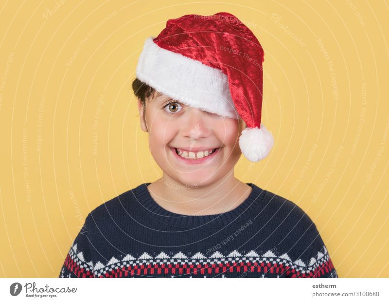 Kind mit Weihnachtsmannmütze auf gelbem Hintergrund Lifestyle Freude Winter Feste & Feiern Weihnachten & Advent Silvester u. Neujahr Mensch maskulin