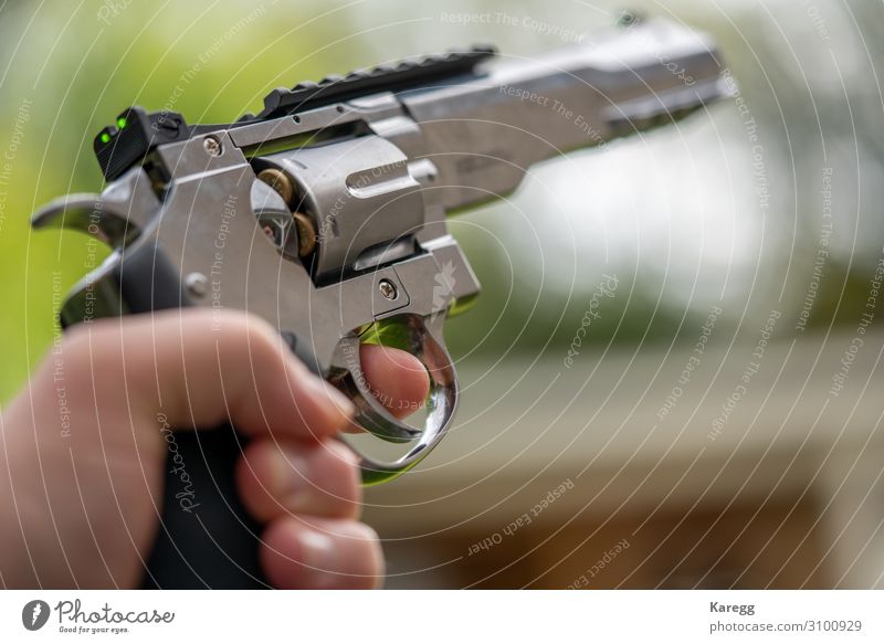 in one hand is large silver heavy revolver and aims into the air Roulette Mensch maskulin Junger Mann Jugendliche Hand 1 8-13 Jahre Kind Kindheit Aggression